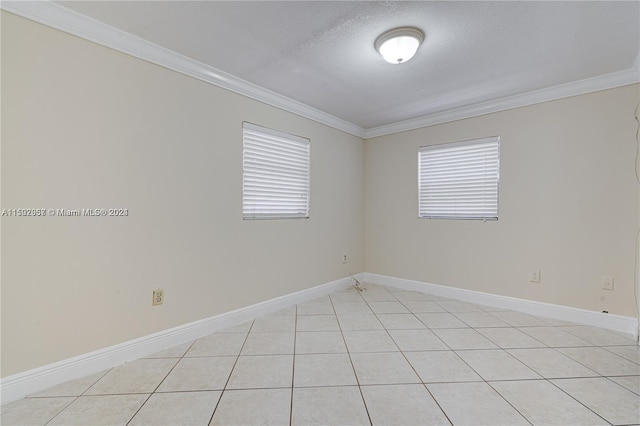 spare room with ornamental molding, a textured ceiling, and light tile floors