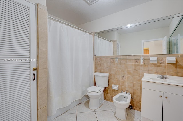 bathroom with tile walls, a bidet, tile floors, and toilet