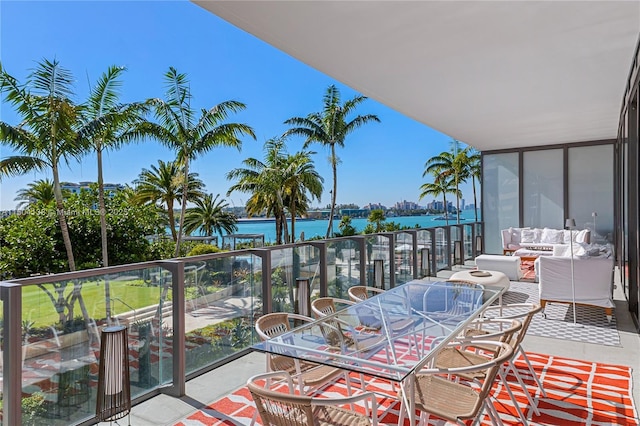 balcony with an outdoor living space and a water view