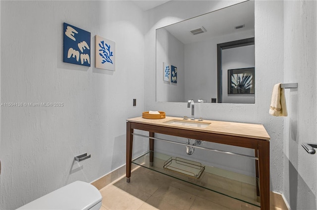 bathroom featuring vanity, tile patterned floors, and toilet