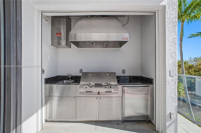 kitchen with sink, wall chimney exhaust hood, and stainless steel built in fridge