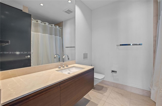 bathroom featuring vanity, tile patterned floors, and toilet