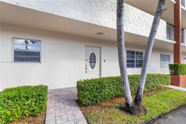 doorway to property featuring stucco siding