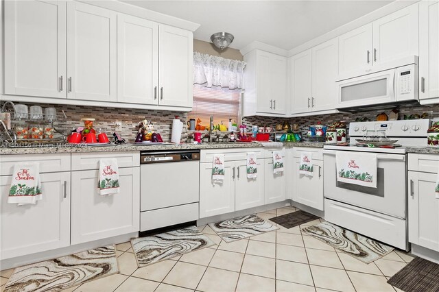 kitchen featuring tasteful backsplash, white appliances, and light tile patterned floors