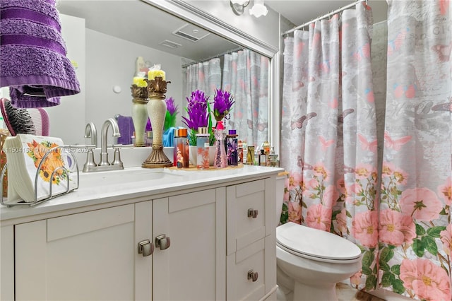 bathroom featuring a shower with curtain, visible vents, vanity, and toilet