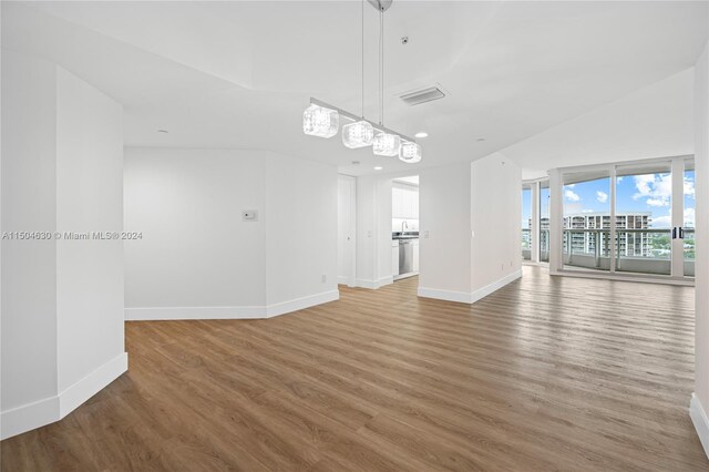 unfurnished living room with hardwood / wood-style flooring and vaulted ceiling