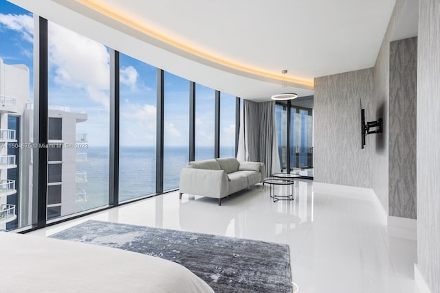 tiled bedroom featuring multiple windows, expansive windows, and a water view