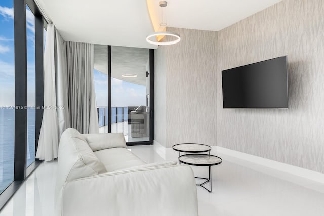 living room featuring tile floors, floor to ceiling windows, and a water view