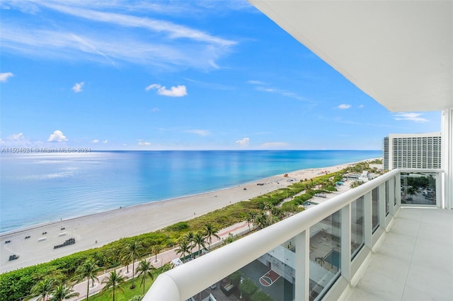 balcony featuring a beach view and a water view