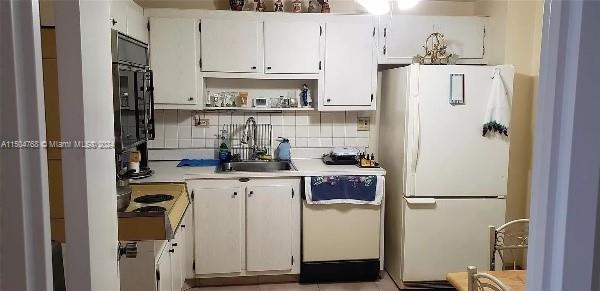 kitchen with white cabinetry, dishwashing machine, tasteful backsplash, sink, and white fridge