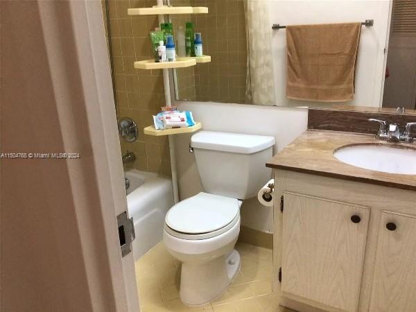 full bathroom featuring tile flooring, vanity, toilet, and shower / tub combo