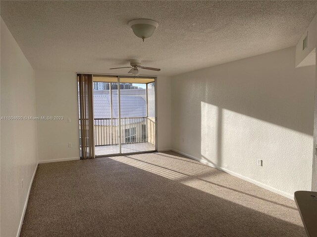 unfurnished room featuring carpet, ceiling fan, and a textured ceiling