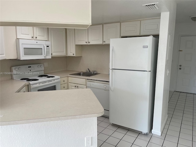 kitchen with light tile patterned flooring, sink, white cabinetry, and white appliances