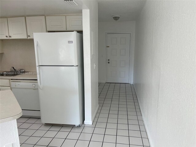 kitchen featuring white cabinetry, white appliances, and light tile patterned floors