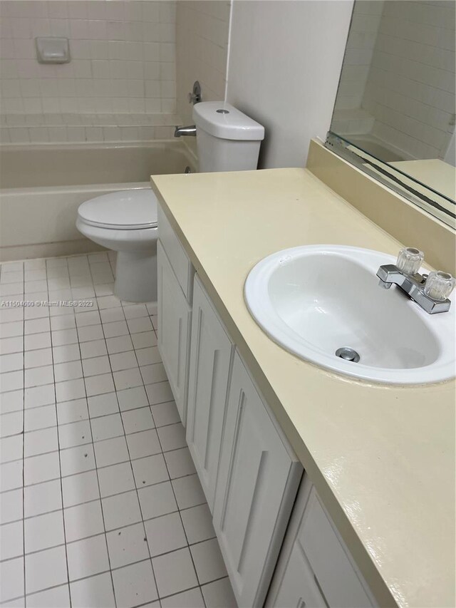 full bathroom with vanity, tile patterned flooring, tiled shower / bath, and toilet