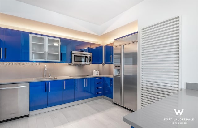 kitchen with sink, decorative backsplash, blue cabinetry, and stainless steel appliances