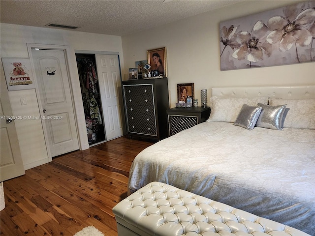 bedroom featuring a textured ceiling, a closet, and dark wood-type flooring