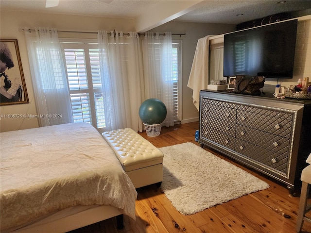 bedroom with a textured ceiling and light wood-type flooring