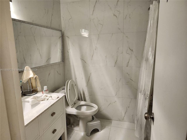 bathroom with tile patterned flooring, vanity, tile walls, and toilet