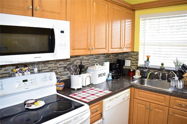 kitchen featuring tasteful backsplash, white appliances, and sink