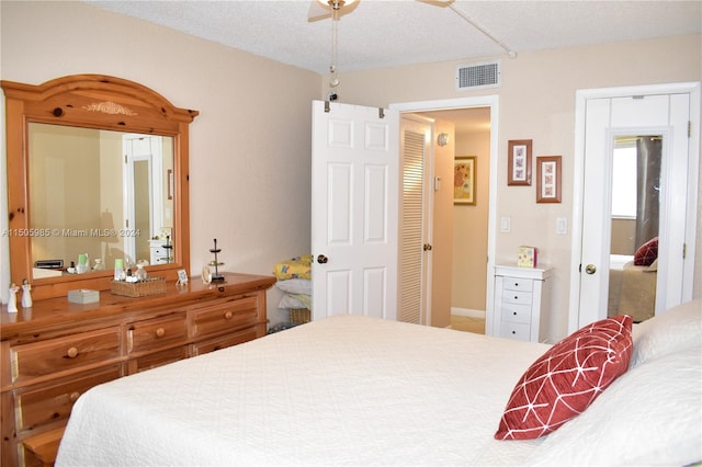 carpeted bedroom with a textured ceiling and ceiling fan