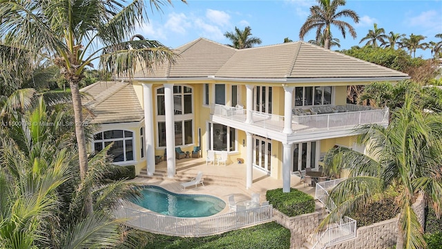 back of house featuring french doors, a balcony, and a patio