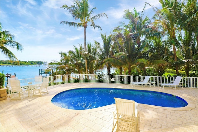 view of swimming pool with a patio area and a water view