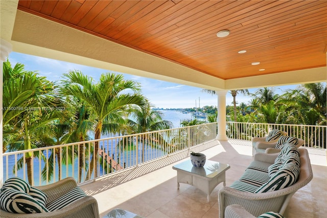 view of patio / terrace with a water view, outdoor lounge area, and a balcony