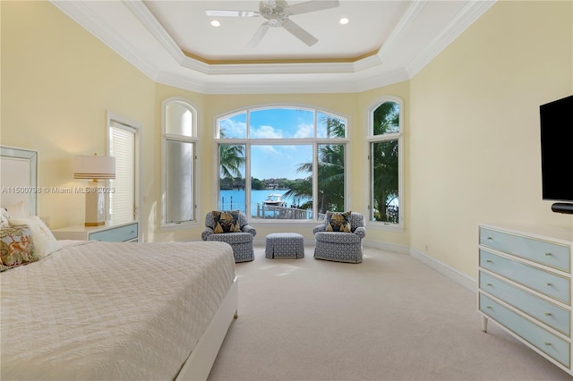 bedroom featuring crown molding, ceiling fan, a tray ceiling, and light carpet