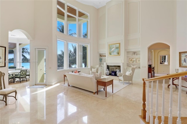 living room with a high ceiling and built in shelves