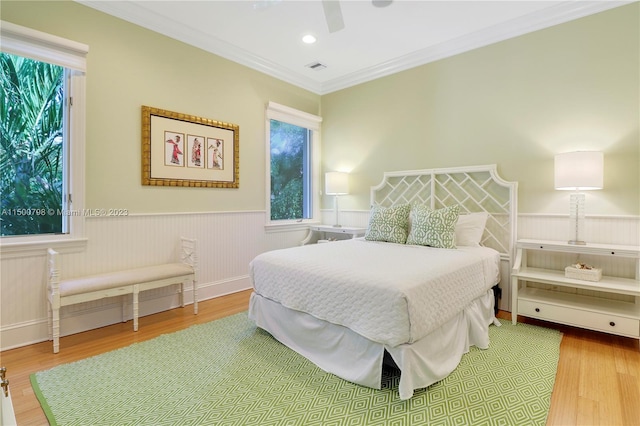 bedroom featuring ceiling fan, light wood-type flooring, and crown molding