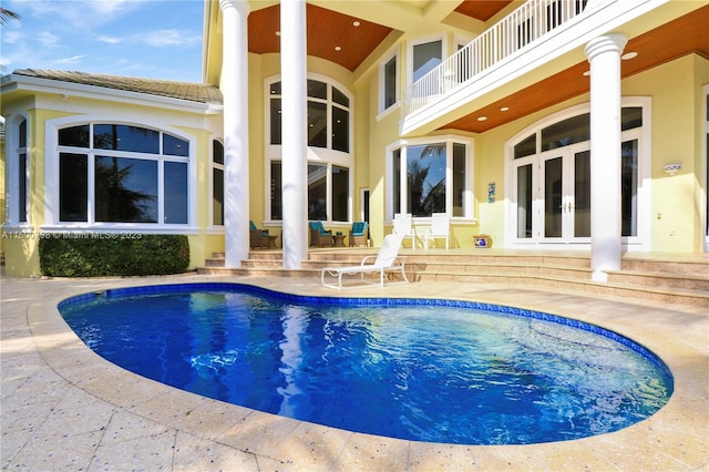 view of swimming pool with french doors and a patio