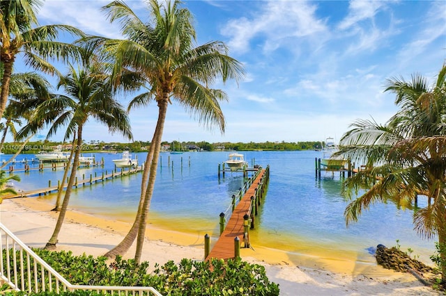 view of dock featuring a water view and a beach view