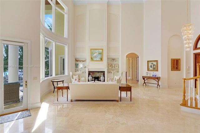 living room with light tile floors, a chandelier, built in features, and a towering ceiling