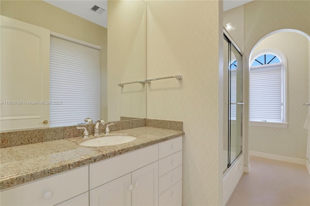 bathroom featuring tile floors, vanity, and bath / shower combo with glass door