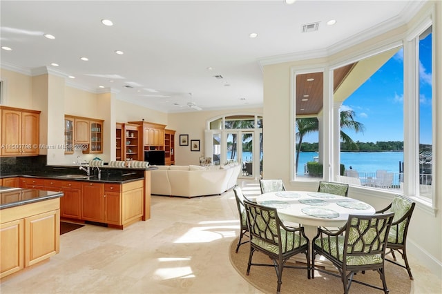 kitchen with light tile floors, ceiling fan, french doors, tasteful backsplash, and a water view