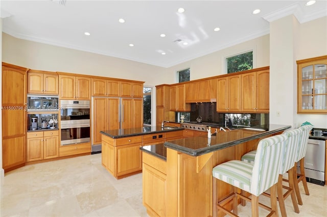 kitchen featuring double oven, a kitchen bar, light tile floors, a kitchen island, and crown molding