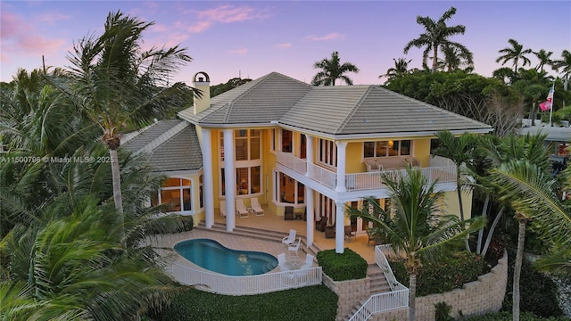 17571 SE Conch Bar Ave, Jupiter, FL 33469 - back house at dusk featuring a balcony and a patio area