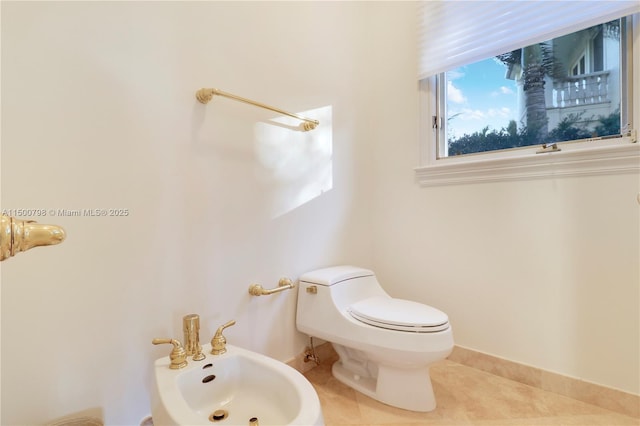 bathroom featuring tile patterned flooring, a bidet, and toilet