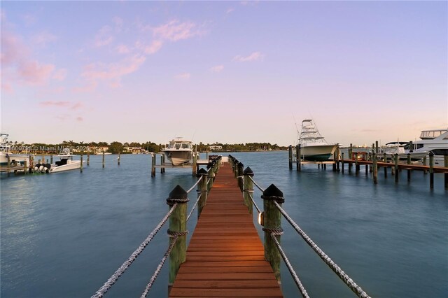 dock area with a water view and a view of the beach