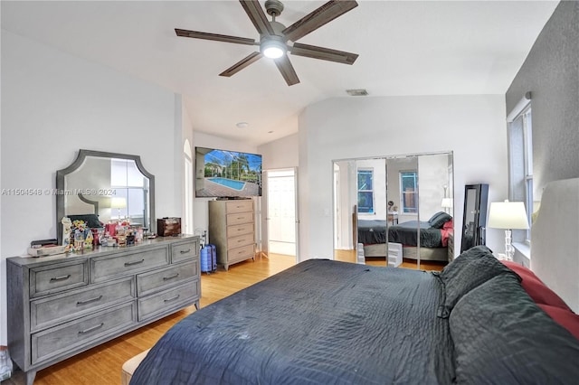 bedroom featuring ceiling fan, multiple windows, vaulted ceiling, and light hardwood / wood-style floors