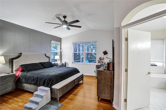 bedroom with ceiling fan, light hardwood / wood-style floors, and vaulted ceiling