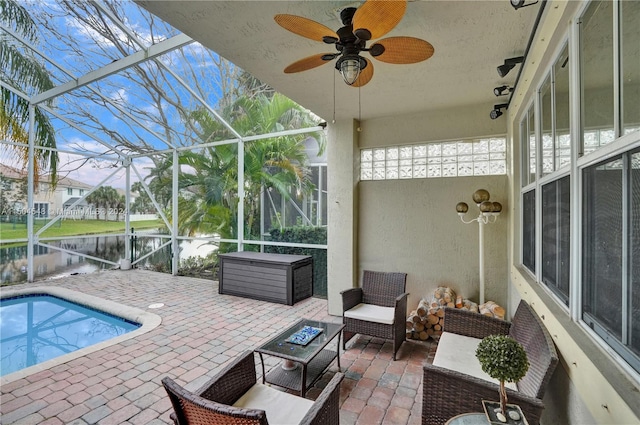 sunroom / solarium with a water view, ceiling fan, and a healthy amount of sunlight