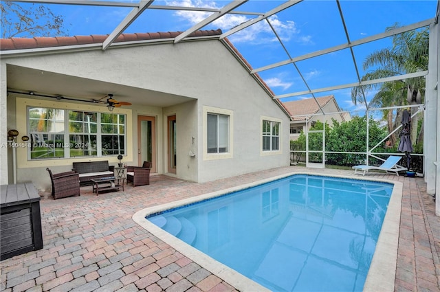 view of pool with a patio area, ceiling fan, an outdoor living space, and a lanai