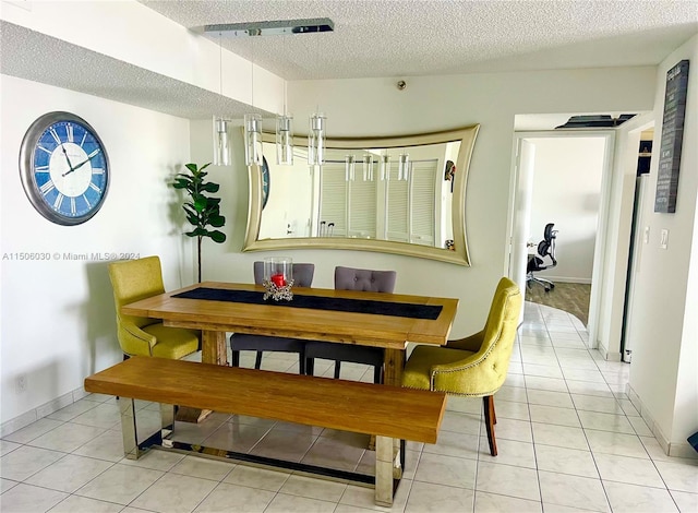 dining space with light tile patterned floors and a textured ceiling