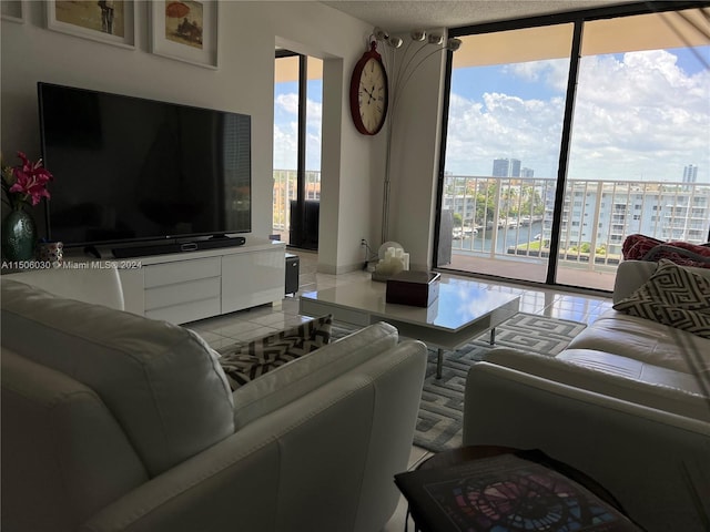 living room with a textured ceiling, tile patterned floors, and a wall of windows