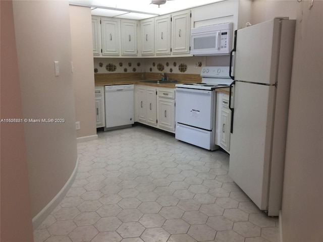 kitchen featuring decorative backsplash, light tile patterned flooring, white cabinets, white appliances, and sink