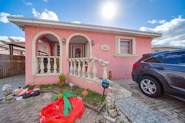 854 E 24th St, Hialeah, FL 33013 - view of front facade featuring a porch, fence, and stucco siding