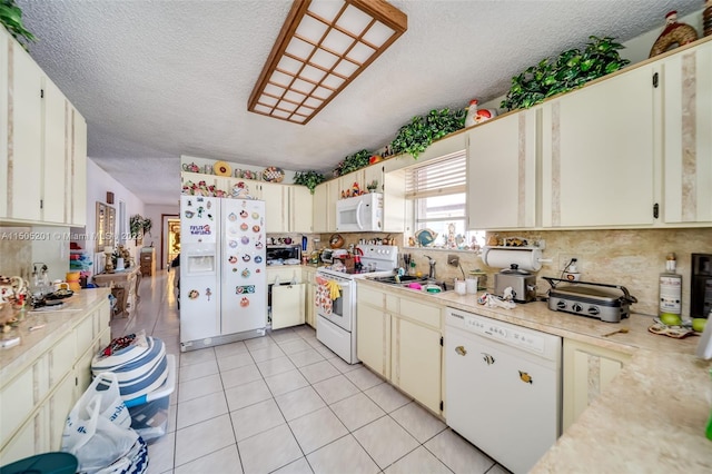 854 E 24th St, Hialeah, FL 33013 - kitchen with a textured ceiling, backsplash, white appliances, light countertops, and light tile patterned floors