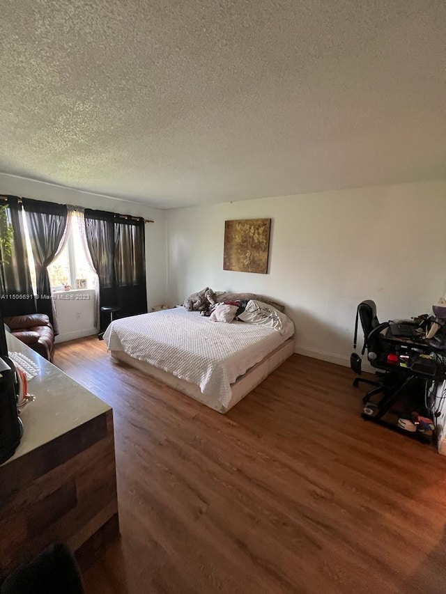 bedroom featuring a textured ceiling and hardwood / wood-style flooring